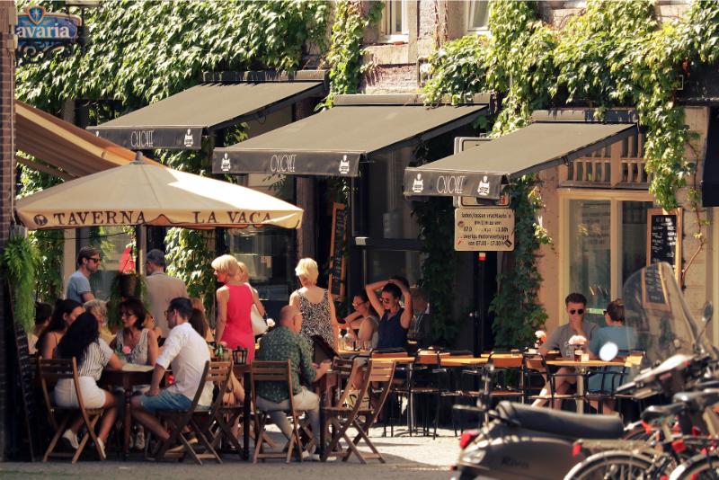 Outside street café customers sitting and walking around